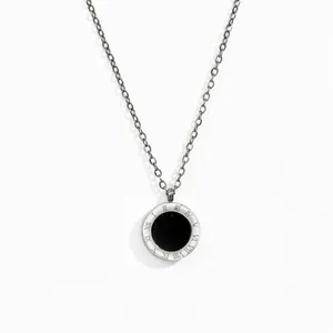 Detail of rose gold necklace featuring double-sided Roman numeral ring and black inlay