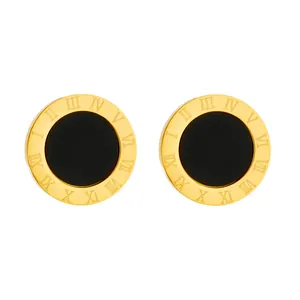 Detailed view of rose gold stud earrings featuring black circular inlay and Roman numerals