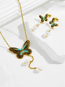 Detailed view of golden butterfly necklace and earrings with turquoise enamel and pearls
