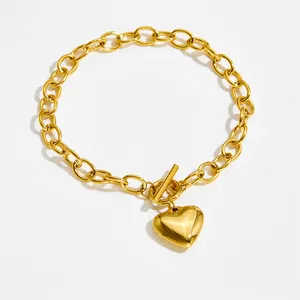 Polished gold heart pendant bracelet with a thick toggle clasp on a white background