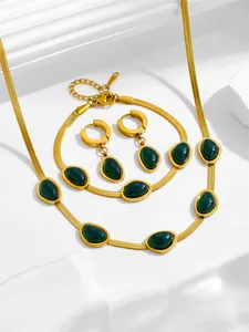 Détail de la parure émeraude avec chaînes serpent et finition dorée sur support pierre