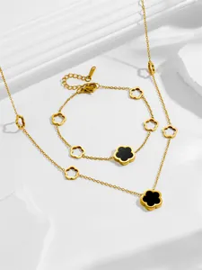 Détails d'un ensemble de bijoux en acier doré avec motifs de trèfle noir élégants
