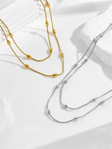 Close-up of double-layer stainless steel snake bone necklace with oval bead accents