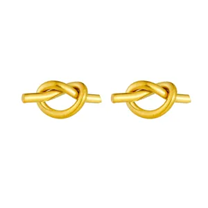 Elegant 18K gold plated knotted heart stud earrings with a matte metallic finish on white background