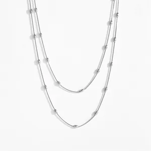 Detail of silver double layer snake chain necklace with polished oval beads for women