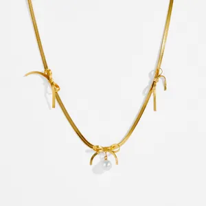 Elegant gold bow necklace with white pearl pendant on minimalist white background