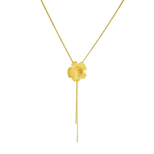 Elegante collar de flor dorada con pétalos cepillados y borlas largas sobre fondo blanco