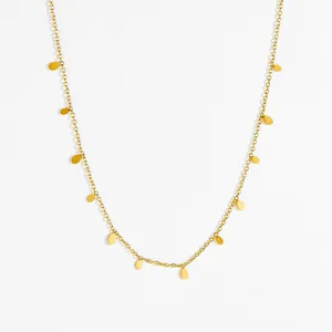 Collar de acero de titanio dorado con pequeños colgantes de gotas de agua en fondo blanco