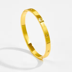 Detailed view of gold plated starburst bangle with cubic zirconia square settings