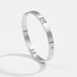 Silver starburst bangle with inlaid zircons and hinged clasp for a minimalist look