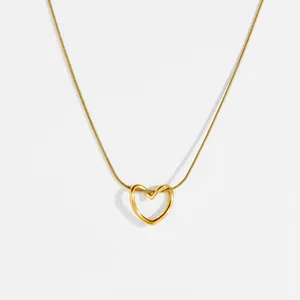 Elegante colgante de corazón hueco de acero dorado con una fina cadena de serpiente