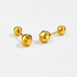 Macro detail of gold heart earrings with hammered texture and 18k gold finish