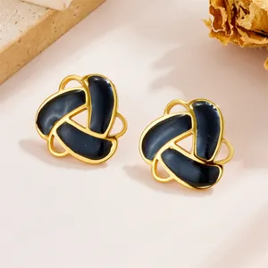 Vintage gold triangle earrings with black enamel inlay on elegant marble background