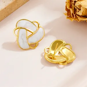 Close-up of vintage geometric triangle earrings with white marble inlay and gold finish