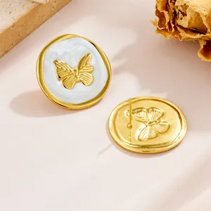 Detail view showing front and back of vintage butterfly earrings with white enamel finish