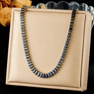 Detalle del collar dorado con piedras preciosas negras rectangulares engastadas