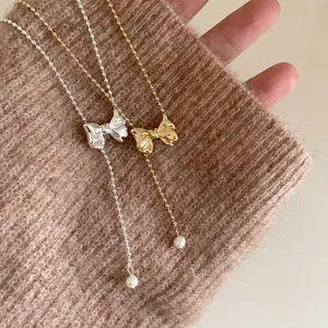 French vintage metallic bow necklace with a freshwater pearl pendant on a beaded chain