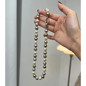 Dettaglio macro della collana di perle sfumate grigie e bianche con chiusura ovale argento