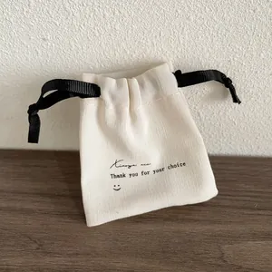 Vue détaillée d'une pochette à bijoux crème avec ruban noir et texte de remerciement