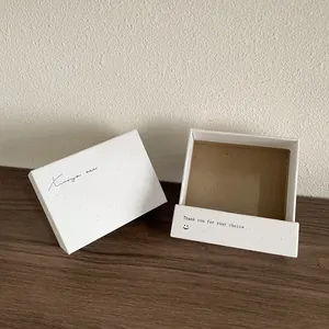 Détail de la boîte à bijoux en papier texturé blanc avec logo Xiang acc élégant