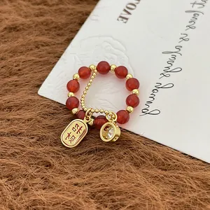 Vista macro de anillo de cuentas rojas estilo chino con amuleto de suerte dorado