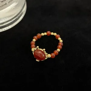 Anillo de estilo chino con cuentas rojas y detalles dorados en un diseño vintage único