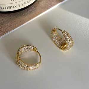 Close-up of gold wide hoop earrings with micro-pave white zircon stones for women