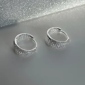 Macro shot of sparkling silver hoop earrings with pave set white cubic zirconia crystals