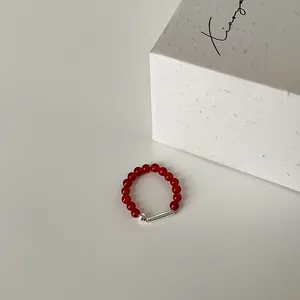 Detailaufnahme von elastischem Ring aus roten Achatperlen mit Silberröhrchen