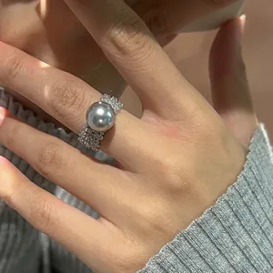 Détail d'une bague de luxe avec perle grise et large anneau serti de zircons cubiques