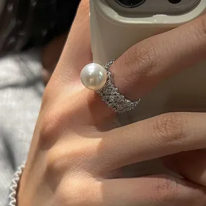 Vue détaillée d'une bague perle avec pavage de zircons et motifs ajourés sophistiqués