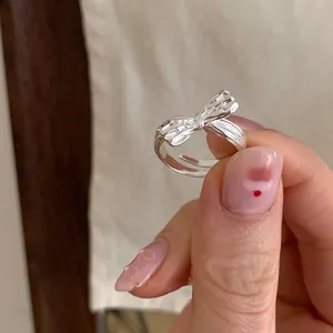 Nahaufnahme eines silbernen Schleifenrings mit strukturierter Oberfläche am Finger