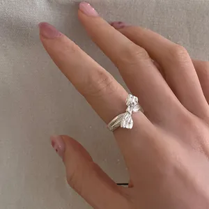 Nahaufnahme eines silbernen Schleifenrings mit strukturierter Oberfläche am Finger