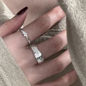 Texturierte Metallic-Stern-Ringe in Silberoptik am Finger getragen mit gemütlichem Flair