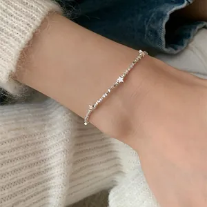 Close-up of minimalist silver chain bracelet with delicate star charms on a female wrist