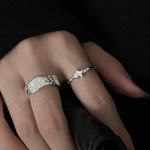 Makroaufnahme von silbernen strukturierten Ringen mit Sternengravur auf poliertem Metall