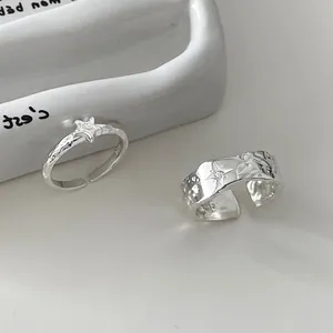 Detail eines S925 Silber Rings mit strukturierter Stern-Gravur auf weißer Keramik