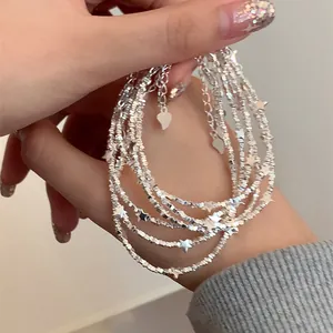 Macro shot of silver multi-layer beaded bracelet with star pendants and heart charm