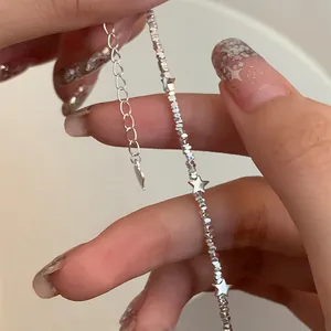Detail of silver star charm bracelet with polished metal beads and extension chain