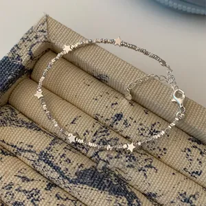 Detail of silver star charm bracelet with irregular faceted silver beads and lobster clasp