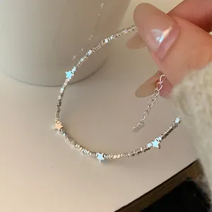 Close-up of silver star charm and irregular silver bead chain on adjustable bracelet