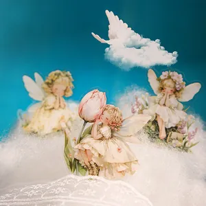 Retro fairy stickers with floral wings set against a dreamy blue sky and cloud background