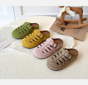 Detail of girl's hollowed out suede clogs in four colors with adjustable metal buckles