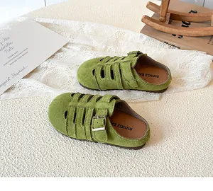Detailed macro view of grass green hollow-out toddler princess sandals with bronze buckles