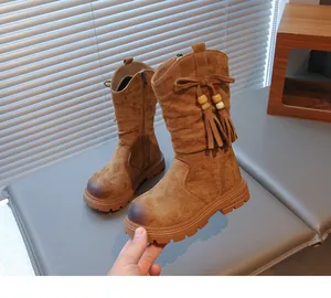 Dettaglio di stivali vintage per bambina in camoscio marrone con frange e zip laterale
