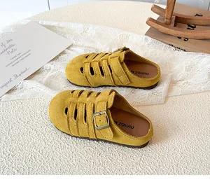 Detail of yellow hollowed suede mule slippers for girls with an adjustable vintage buckle