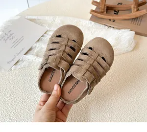 Detail shot of brown hollow-out girls' princess sandals with buckle and woven texture