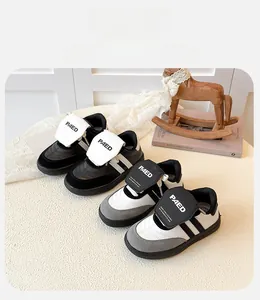 Détail de baskets pour filles avec bandes velcro et logo PAED sur un coussin crème doux