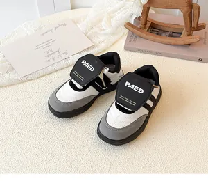 Gros plan de baskets noir et blanc pour filles avec velcro sur un fond en peluche