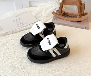 Détails des baskets filles noir et blanc avec lettrage PAED et rayures latérales blanches